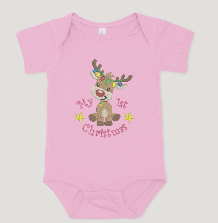 Pink baby onesie with a reindeer design and text on a light gray background